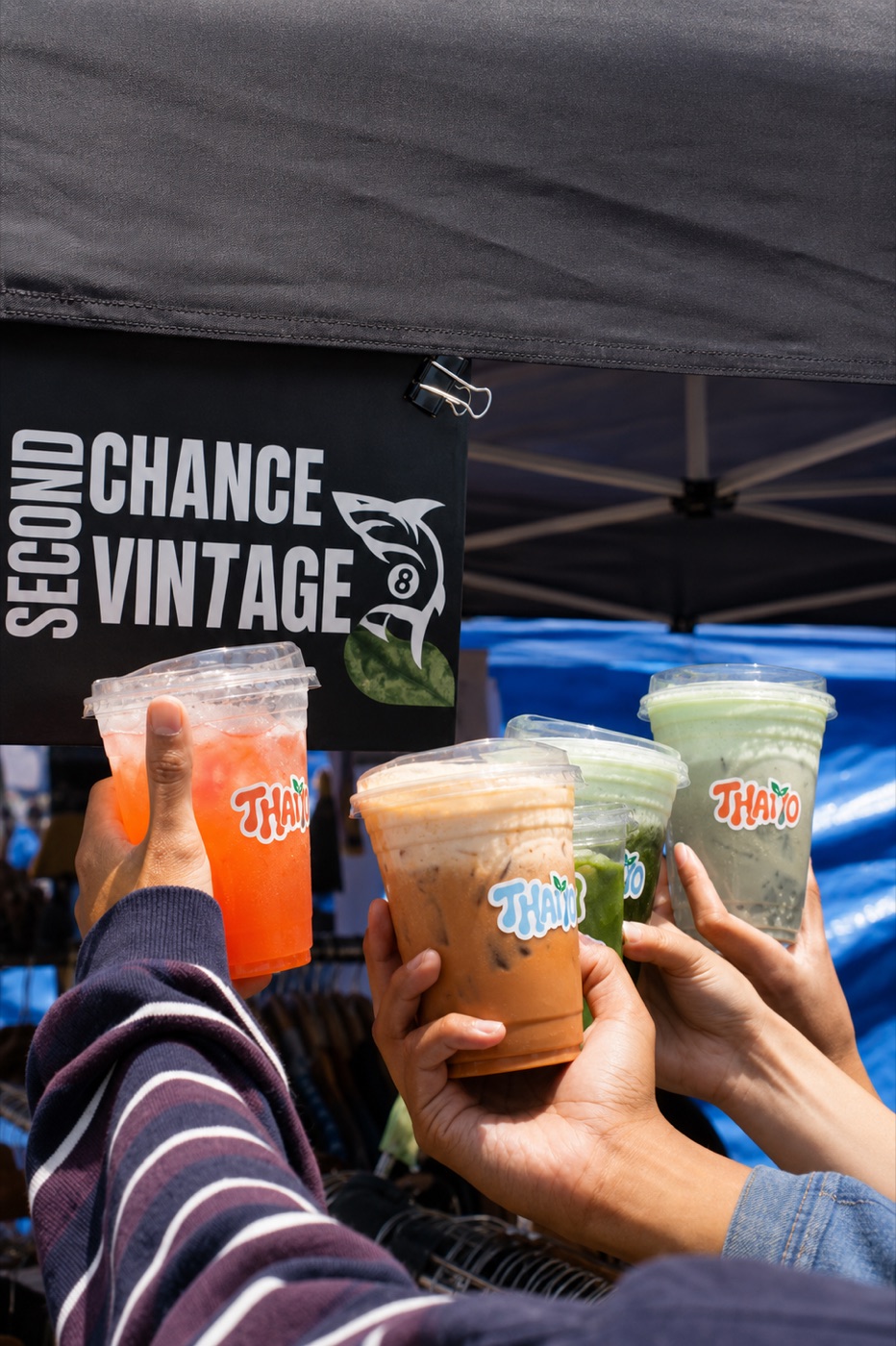 Friends toasting Thaiyo drinks under the pop-up tent