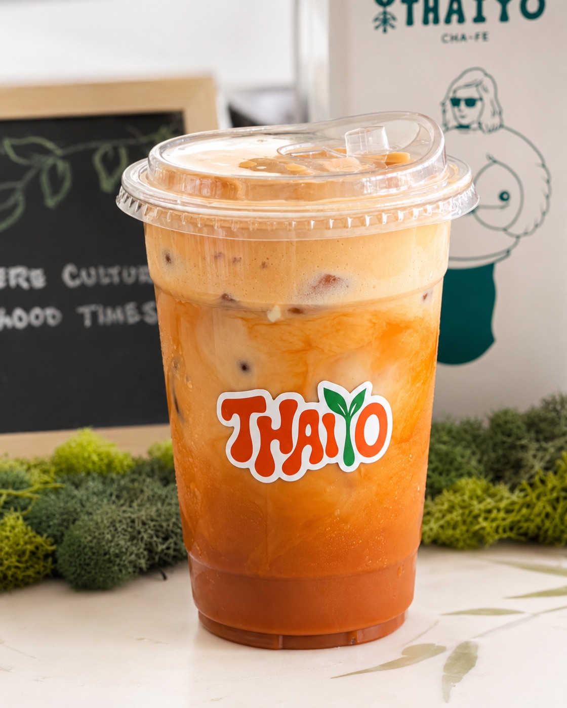 Iced Thai tea beside a good cultures good times chalkboard